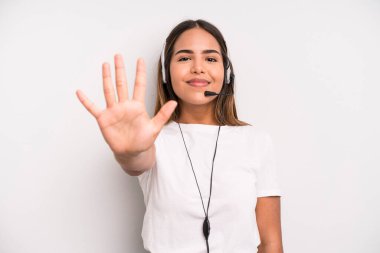 hispanic pretty woman smiling and looking friendly, showing number five. telemarketer concept