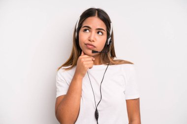 hispanic pretty woman thinking, feeling doubtful and confused. telemarketer concept