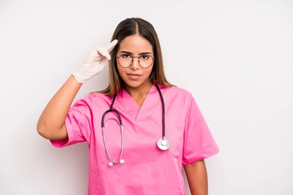 Hispanic Pretty Woman Feeling Confused Puzzled Showing You Insane Medicine — Stockfoto