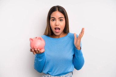 İspanyol güzel kadın kendini mutlu hissediyor ve inanılmaz bir şeye hayret ediyor. Domuz kumbarası konsepti