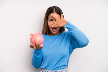 İspanyol güzel kadın şok olmuş, korkmuş ya da korkmuş görünüyor, yüzünü elleriyle kapatıyor. Domuz kumbarası konsepti
