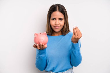 İspanyol güzel kadın kapiş ya da para hareketi yapıp sana ödemeni söylüyor. Domuz kumbarası konsepti