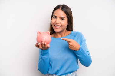 İspanyol güzel kadın heyecanlı ve şaşırmış görünüyor. Domuz kumbarası konsepti