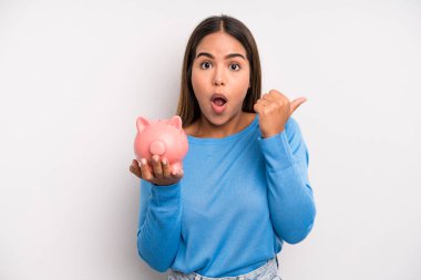 İspanyol güzel bir kadın inançsızlığa şaşırmış görünüyor. Domuz kumbarası konsepti