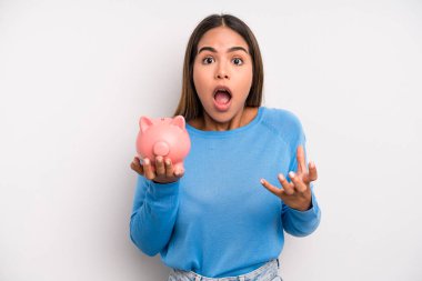 İspanyol güzel kadın inanılmaz bir sürprizle şaşkın, şaşkın ve şaşkın. Domuz kumbarası konsepti