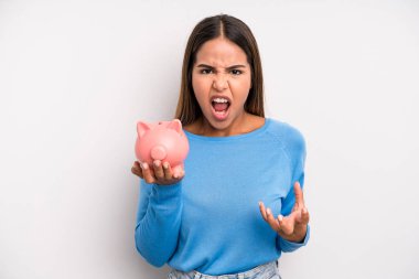 İspanyol güzel kadın sinirli, sinirli ve hayal kırıklığına uğramış görünüyor. Domuz kumbarası konsepti