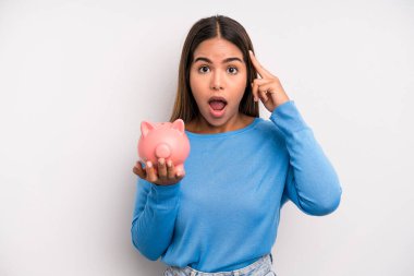 İspanyol güzel kadın şaşırmış görünüyor, yeni bir düşünce, fikir ya da konsept fark ediyor. Domuz kumbarası konsepti