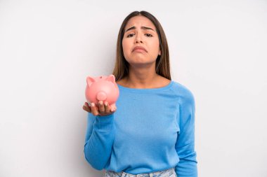 İspanyol güzel bir kadın üzgün ve mızmızlanıyor. Mutsuz bir bakışı var ve ağlıyor. Domuz kumbarası konsepti