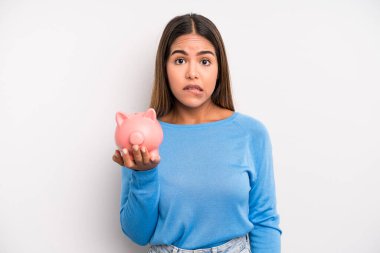 Şaşkın ve şaşkın görünen İspanyol güzel kadın. Domuz kumbarası konsepti