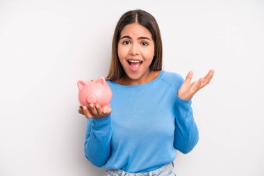 İspanyol güzel kadın kendini mutlu hissediyor, bir çözüm ya da fikir bulduğuna şaşırıyor. Domuz kumbarası konsepti
