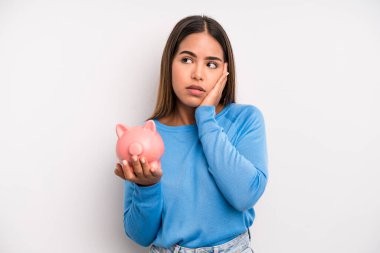 İspanyol güzel kadın bıkkın, yorgun ve uykulu hissediyor. Domuz kumbarası konsepti