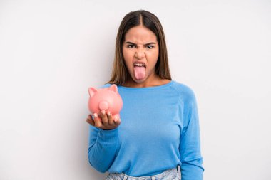 İspanyol güzel kadın iğreniyor, sinirleniyor ve dili dışarı çıkıyor. Domuz kumbarası konsepti