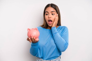 İspanyol güzel kadın mutlu, heyecanlı ve şaşırmış hissediyor. Domuz kumbarası konsepti