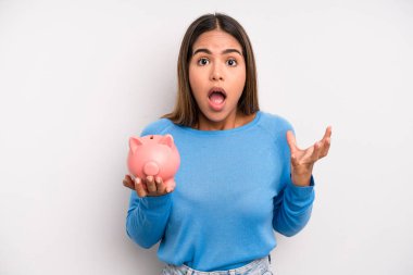 İspanyol güzel kadın son derece şaşırmış ve şok olmuş hissediyor. Domuz kumbarası konsepti