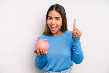 İspanyol güzel kadın bir fikri fark ettikten sonra mutlu ve heyecanlı bir dahi gibi hissediyor. Domuz kumbarası konsepti