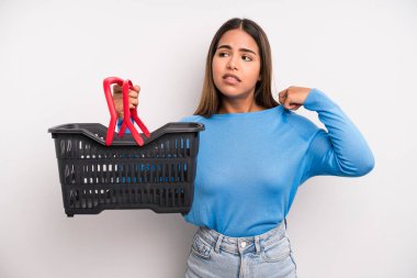 hispanic pretty woman feeling stressed, anxious, tired and frustrated. empty supermarket basket concept