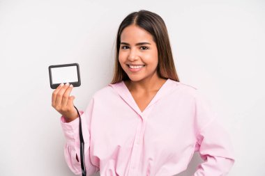 hispanic pretty woman smiling happily with a hand on hip and confident. pass id card concept