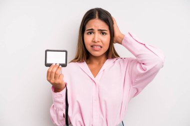 hispanic pretty woman feeling stressed, anxious or scared, with hands on head. pass id card concept