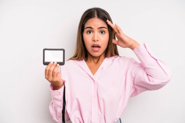 hispanic pretty woman looking happy, astonished and surprised. pass id card concept