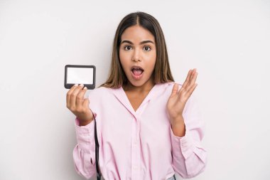 hispanic pretty woman feeling happy and astonished at something unbelievable. pass id card concept