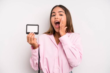 hispanic pretty woman feeling happy,giving a big shout out with hands next to mouth. pass id card concept