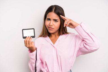 hispanic pretty woman feeling confused and puzzled, showing you are insane. pass id card concept