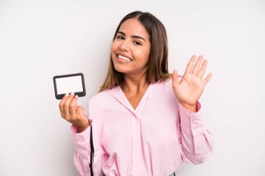 hispanic pretty woman smiling happily, waving hand, welcoming and greeting you. pass id card concept