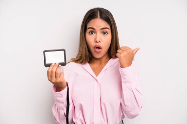 hispanic pretty woman looking astonished in disbelief. pass id card concept