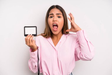 hispanic pretty woman screaming with hands up in the air. pass id card concept