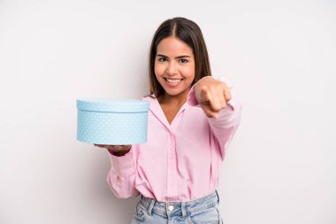 hispanic pretty woman pointing at camera choosing you. gift box concept
