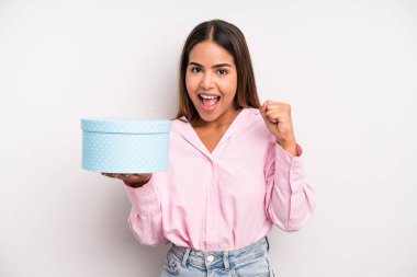 hispanic pretty woman feeling shocked,laughing and celebrating success. gift box concept