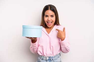 hispanic pretty woman feeling happy and pointing to self with an excited. gift box concept