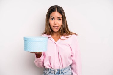 hispanic pretty woman looking puzzled and confused. gift box concept