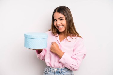 hispanic pretty woman feeling happy and facing a challenge or celebrating. gift box concept