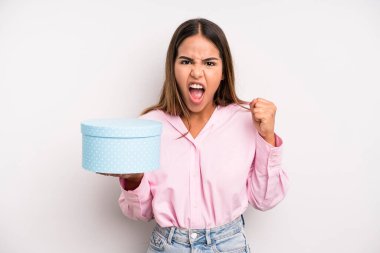 hispanic pretty woman shouting aggressively with an angry expression. gift box concept