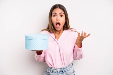 hispanic pretty woman feeling extremely shocked and surprised. gift box concept
