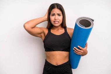 İspanyol güzel kadın kendini stresli, endişeli ya da korkmuş hissediyor, elleri başının üstünde. fitness ve yoga konsepti