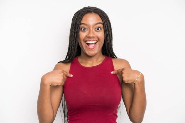 black young adult woman feeling happy, surprised and proud, pointing to self with an excited, amazed look