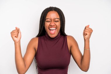 black young adult woman looking extremely happy and surprised, celebrating success, shouting and jumping