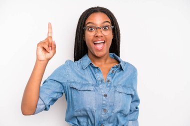 black young adult woman feeling like a happy and excited genius after realizing an idea, cheerfully raising finger, eureka!