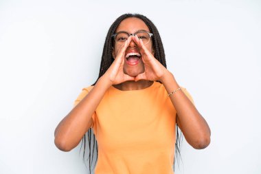 black young adult woman feeling happy, excited and positive, giving a big shout out with hands next to mouth, calling out