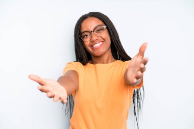 black young adult woman smiling cheerfully giving a warm, friendly, loving welcome hug, feeling happy and adorable