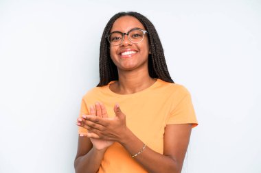 black young adult woman feeling happy and successful, smiling and clapping hands, saying congratulations with an applause