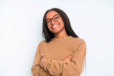 black young adult woman laughing happily with arms crossed, with a relaxed, positive and satisfied pose