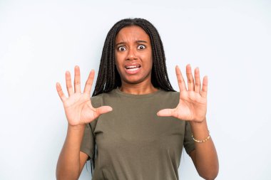 black young adult woman feeling stupefied and scared, fearing something frightening, with hands open up front saying stay away