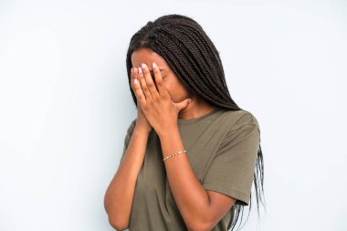 black young adult woman covering eyes with hands with a sad, frustrated look of despair, crying, side view