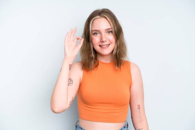 caucasian pretty woman feeling happy, relaxed and satisfied, showing approval with okay gesture, smiling