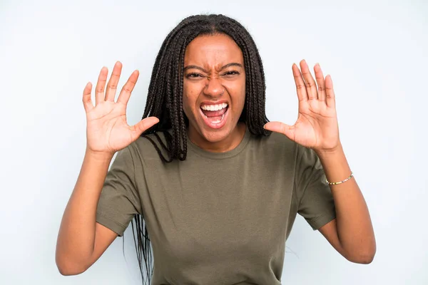 stock image black young adult woman screaming in panic or anger, shocked, terrified or furious, with hands next to head