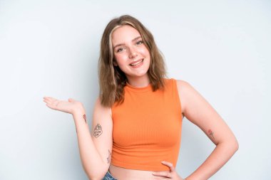 caucasian pretty woman smiling, feeling confident, successful and happy, showing concept or idea on copy space on the side
