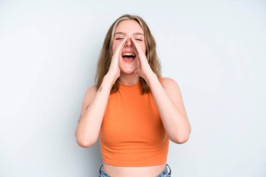 caucasian pretty woman feeling happy, excited and positive, giving a big shout out with hands next to mouth, calling out